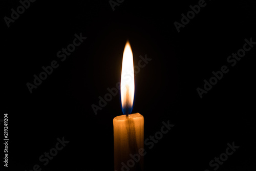 Candle light flame against black background. Concept of memory, remembrance, mourning, grief, and sorrow.