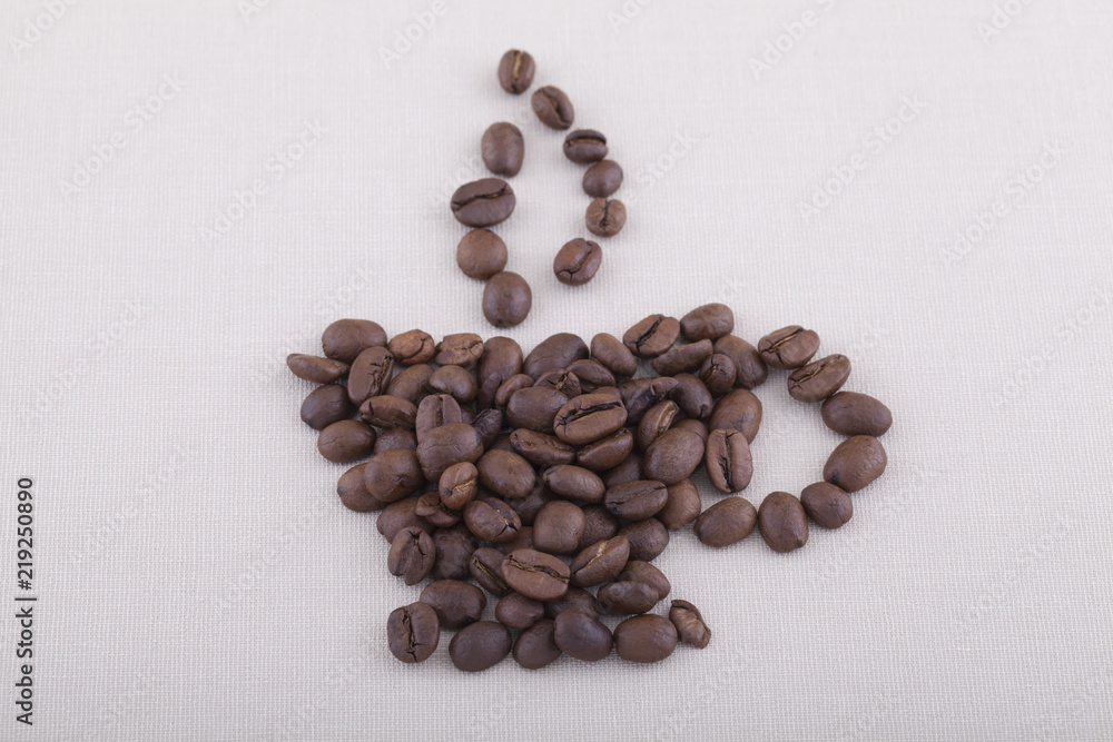 Smoke and coffee cup shaped coffee beans on textile background Smoke and coffee cup shaped coffee beans on textile background
