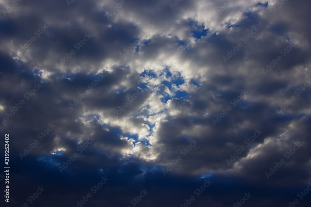 Obraz premium View on beautiful white and gray clouds in a blue sky. Clouds and Skies in the afternoon. The Sun behind Clouds. Fresh Air. Cloudy Weather. Cloud Formations...