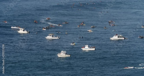 Group of boats and jet skis supporting big wave surf session in Hawaii
