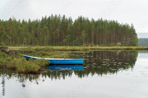 Lonely blue boat in remote forest lake