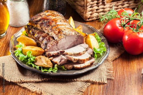 Photos Roasted pork loin with baked potatoes and herbs
