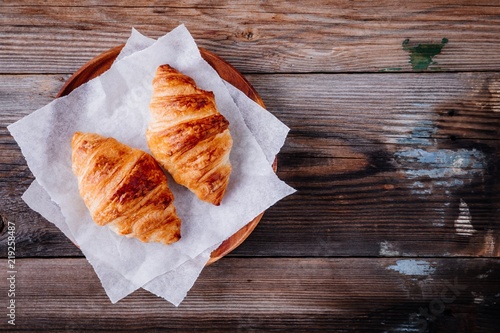 Homemade baked croissants on wooden rustic background. Top view