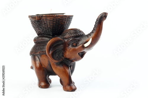 Brown elephant made of resin like wood carving with candle holder with white ivory. Stand on white background, Isolated, Art Model Thai Crafts, For decoration Like in the spa. photo