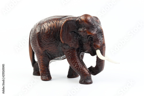 Brown elephant made of resin like wood carving with candle holder with white ivory. Stand on white background, Isolated, Art Model Thai Crafts, For decoration Like in the spa. © Thanachai