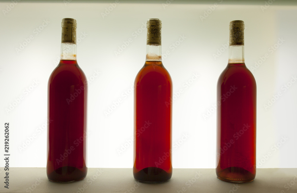 Three bottles of rosé or pinkish wine with different tones Three bottles of rosé or pinkish wine with different tones