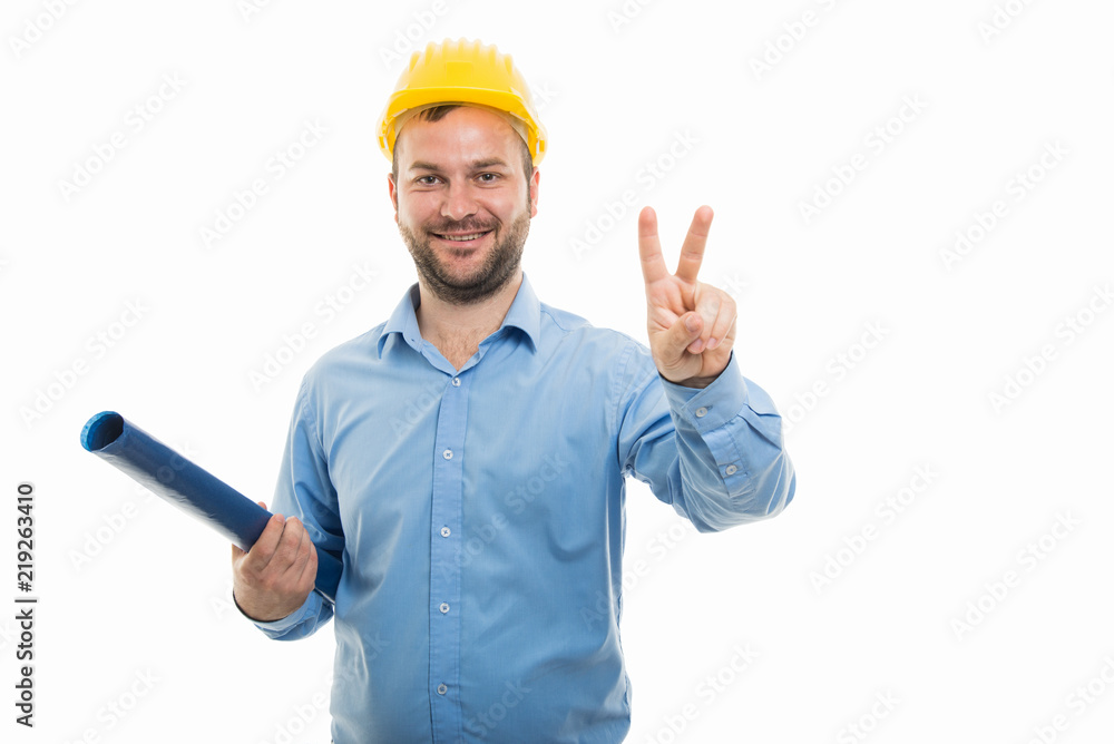 Young architect holding blueprints and showing victory gesture