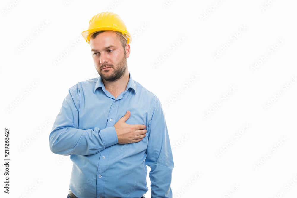 Young architect with yellow helmet showing chest pain gesture Young architect with yellow helmet showing chest pain gesture