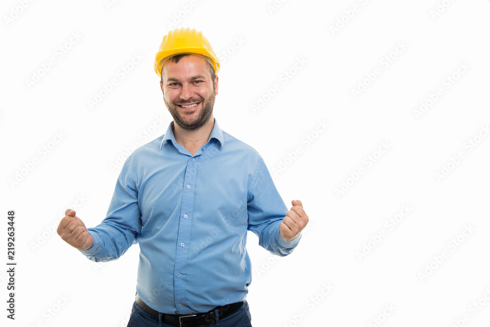 Young architect with yellow helmet showing winning gesture