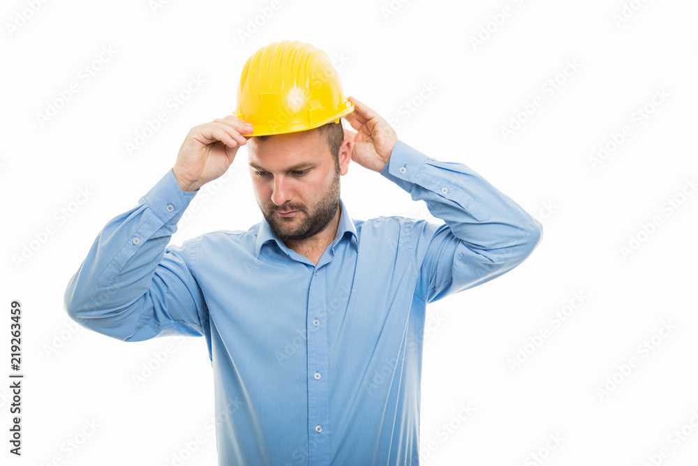 Young architect putting yellow helmet on