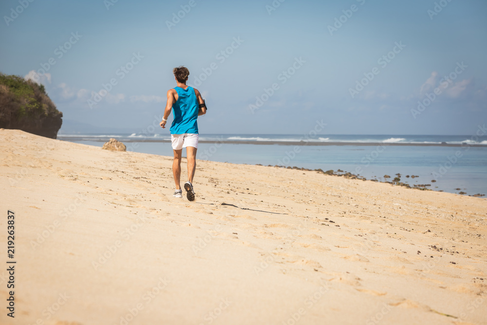 back view of jogger on sea shore, Bali, Indonesia