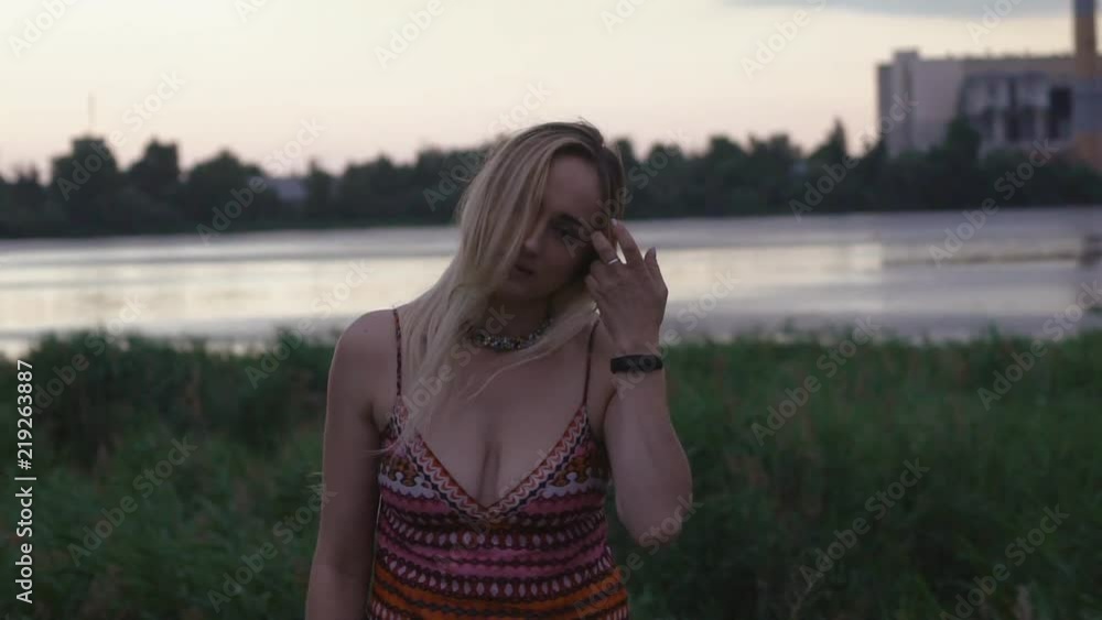 A young, pleasant girl blondes at the lake late at night. The wife's party. A hippie woman with piercings in her face. An attractive woman with a punctured lip and nose looks into the camera. sunset A young, pleasant girl blondes at the lake late at night. The wife's party. A hippie woman with piercings in her face. An attractive woman with a punctured lip and nose looks into the camera. sunset