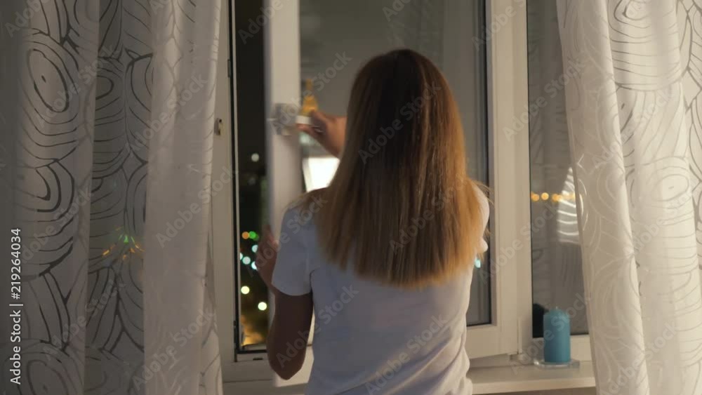 The Woman Closes The Window And The Curtains Before Going To Sleep At Home The Woman Closes The Window And The Curtains Before Going To Sleep At Home