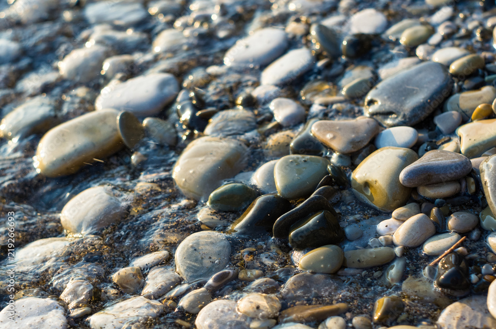 pebble stones on the sea beach, the rolling waves of the sea with foam pebble stones on the sea beach, the rolling waves of the sea with foam