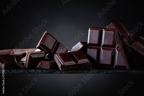 Broken chocolate pieces on a black background.
