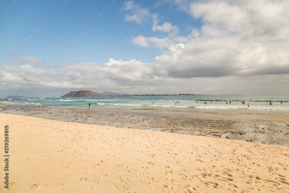 Surf school students in the waves of  Fuerteventura, Canary Islands, Spain.