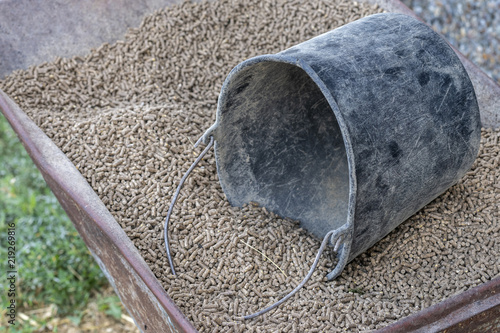 Foto Wheelbarrow with pressed feed chunks and a black bucket .