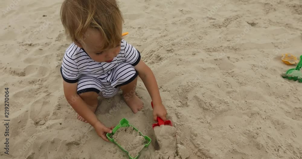 Young boy playing in the sand on the beach