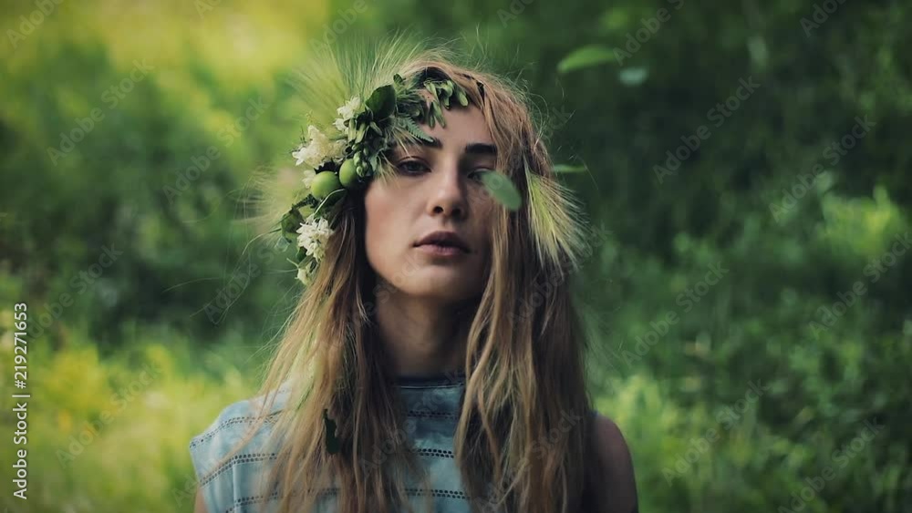 Vertical video. Portrait of mystical girl in the woods hold a ritual. She dressed in long dresses with wreath on the head. Witches, esoteric sessions, magic, divination, otherworldly forces Vertical video. Portrait of mystical girl in the woods hold a ritual. She dressed in long dresses with wreath on the head. Witches, esoteric sessions, magic, divination, otherworldly forces