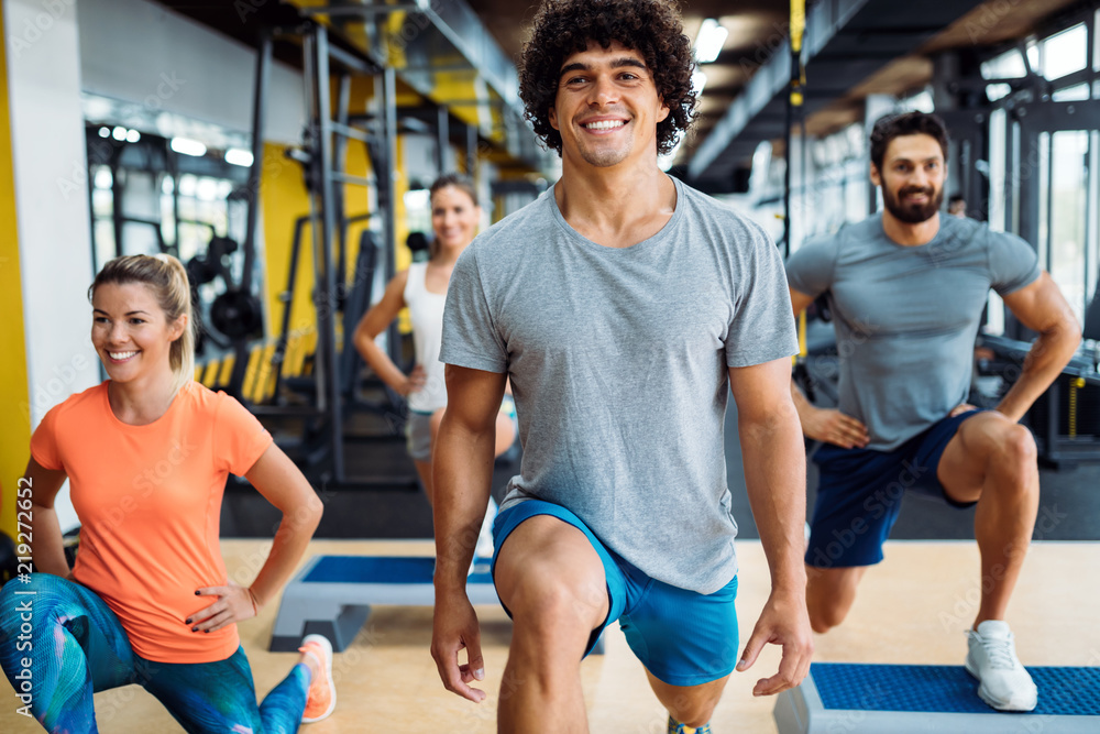 Group of young people doing exercises in gym