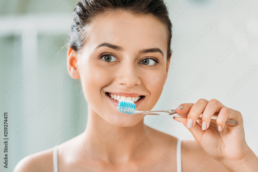 beautiful smiling girl brushing teeth in bathroom beautiful smiling girl brushing teeth in bathroom