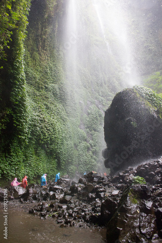 Walking below majestic walterfall photo