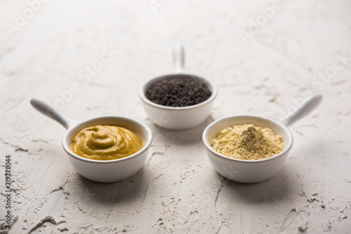 Rai or raw Mustard with sauce, powder and oil, over moody background. Selective focus
