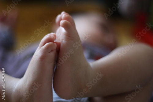 Photo de pieds de bébé avec le corps flouté  © georgio