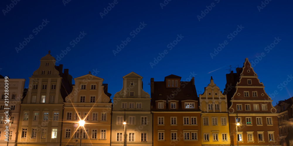 noise pollution soft focus old medieval building facade, lantern illumination, night blue sky, long exposure