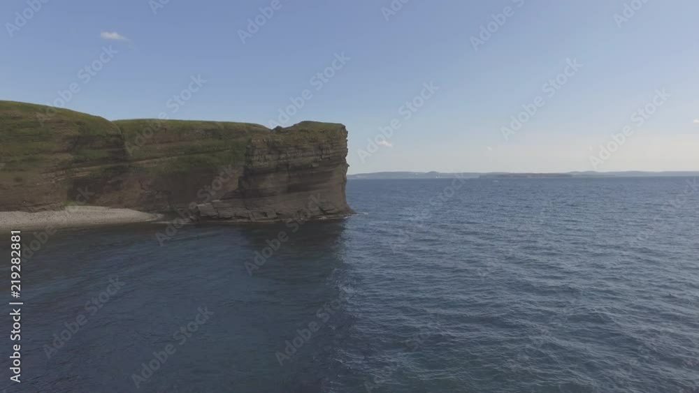 Rocky coastline viewed from above the water on a sunny summer day. Rocky coastline viewed from above the water on a sunny summer day.