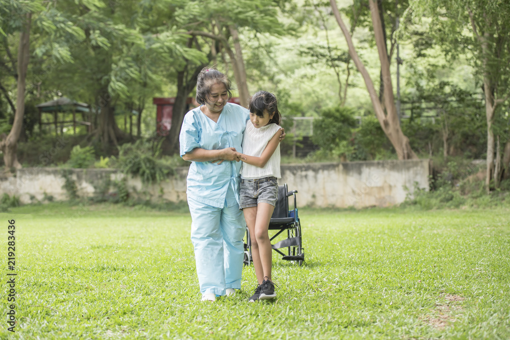 Elderly grandmother in wheelchair with granddaughter in the hospital garden Elderly grandmother in wheelchair with granddaughter in the hospital garden