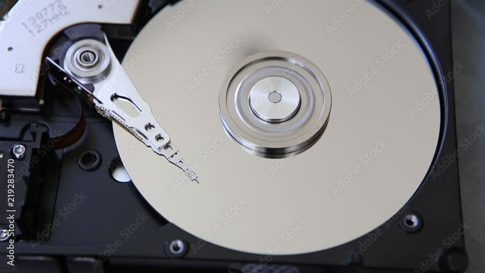 Hard Disk Drive, computer data storage, mirror surface The disc rotates the heads slid by the working surfaces, then the heads are parked and the disk stops Close-up Hard Disk Drive, computer data storage, mirror surface The disc rotates the heads slid by the working surfaces, then the heads are parked and the disk stops Close-up