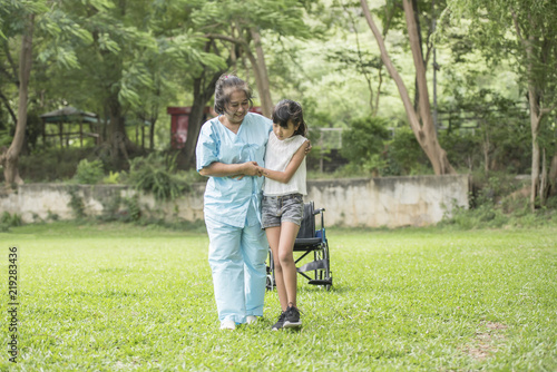 Elderly grandmother in wheelchair with granddaughter in the hospital garden