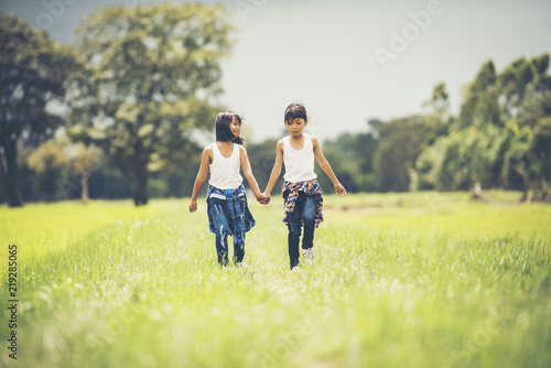 Two little girls hand holding together having fun in the park