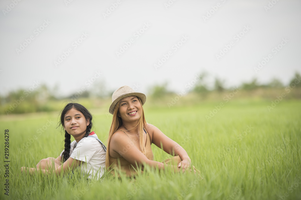 Happy mother with daughter sitting on the grass field park Happy mother with daughter sitting on the grass field park