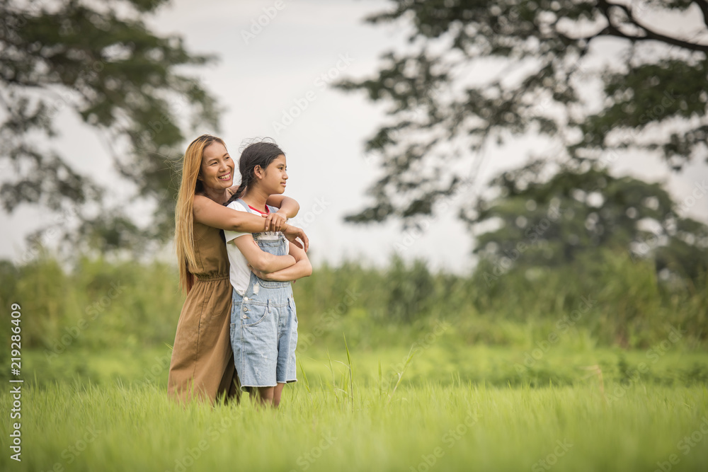 Mother and daughter standing happy in grass field Mother and daughter standing happy in grass field