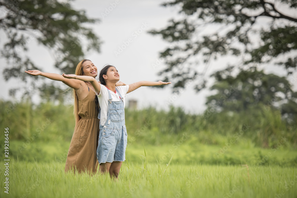 Mother and daughter standing happy in grass field Mother and daughter standing happy in grass field