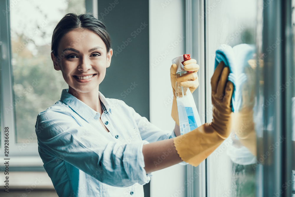 Young Smiling Woman Washing Window with Sponge