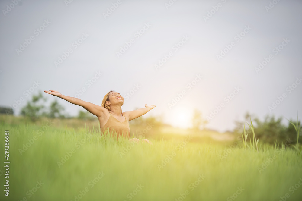 Young woman sitting feel good in grass field. Young woman sitting feel good in grass field.
