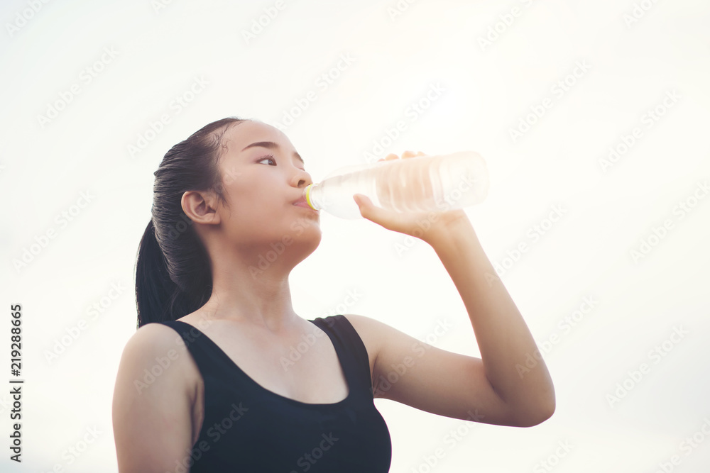 Beautiful young fitness woman drinking water after running exercise Beautiful young fitness woman drinking water after running exercise