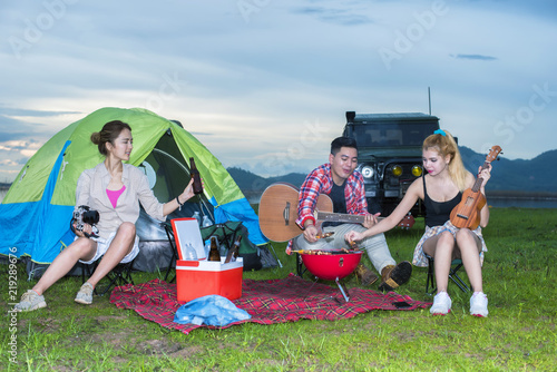 Group asian of man and women have friendship enjoy camping for picnic and barbecue at lake with tents on background  travel concept and happy familly. © analysis121980