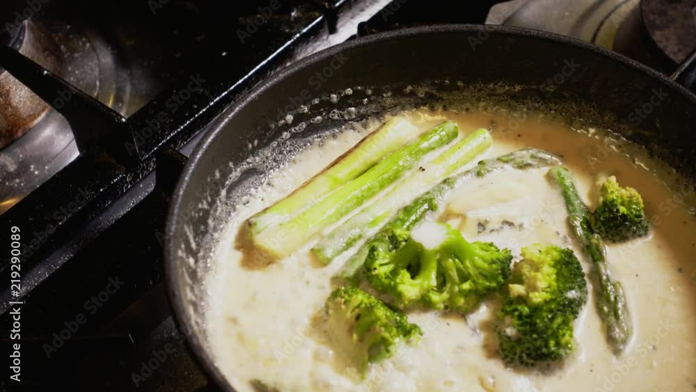 Broccoli frying in a pot with cream Broccoli frying in a pot with cream