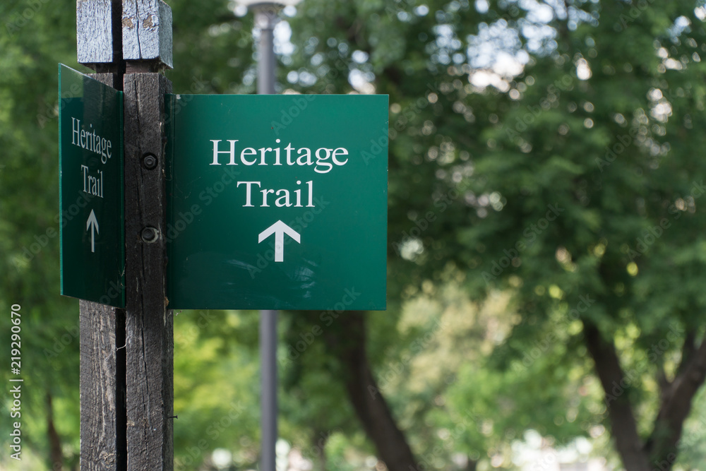 Heritage Trail sign on wood post marking symbol for nature hike walk through historical landmarks