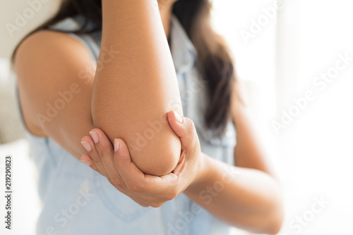 Close up woman having pain in injured elbow. Health care and arm pain concept.