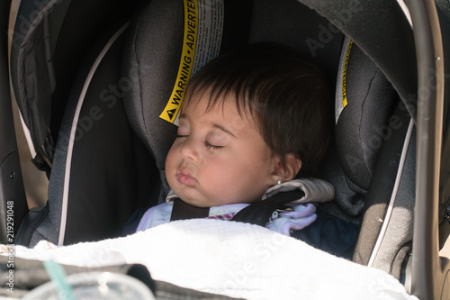 Foto Adorable infant baby girl sleeping in protective car seat