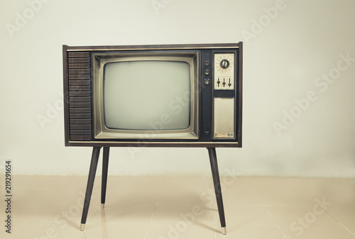Retro tv with wood case on stand at wall background, vintage old TV with stand on the floor in the room.