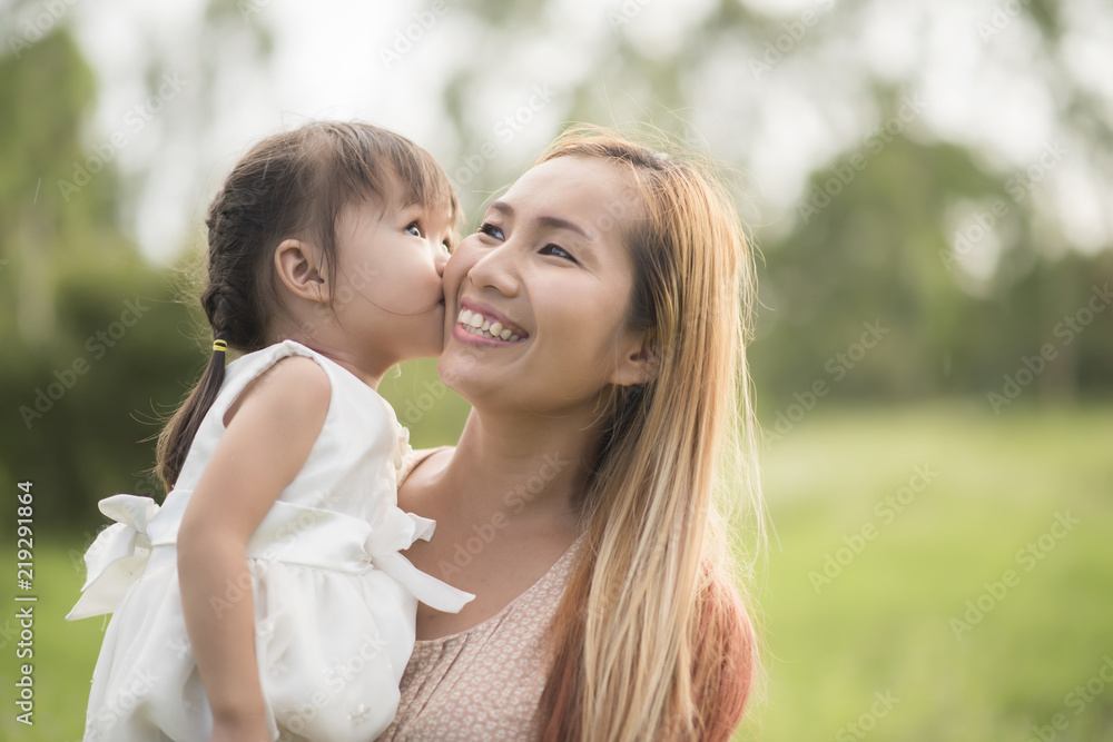 Mother and little daughter playing together in a park Mother and little daughter playing together in a park