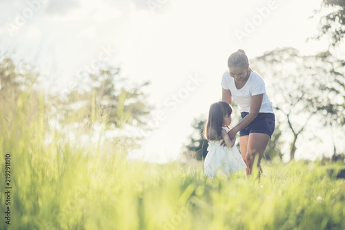 Mother and little daughter playing together in a park © Johnstocker