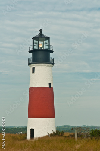Front view, long distance of an operational lighthouse warning mariners of the shoreline of a barrier island in the north atlantic ocean on a chilly, cloudy, autumn day