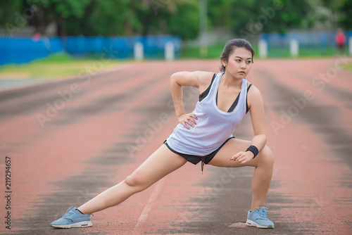 Asian sporty woman stretching body breathing fresh air in the park,Thailand people,Fitness and exercise concept,Jogging in the track